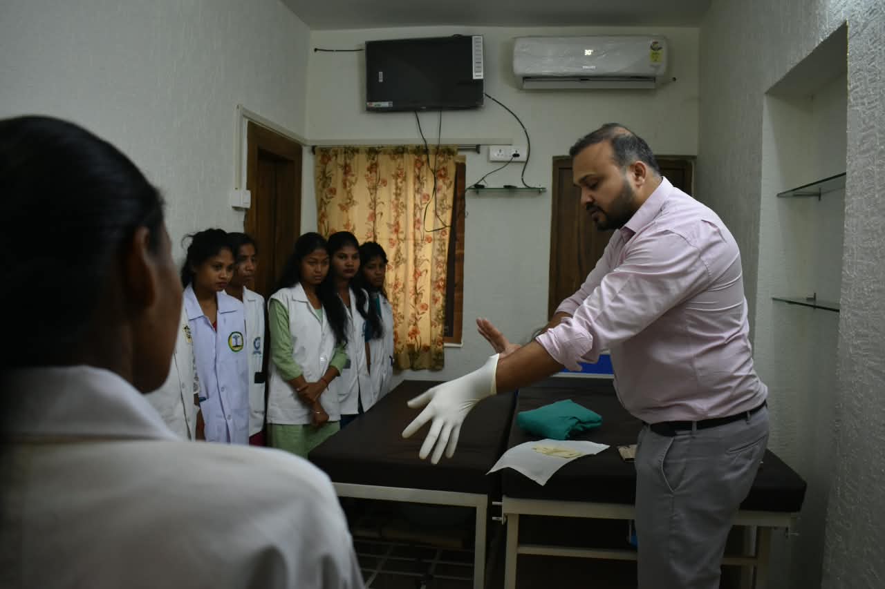 Dr. Ekansh Debuka demonstrating glove technique to nursing students